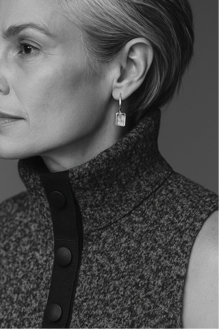 Black and white portrait of a woman wearing a sleeveless textured garment with buttons.