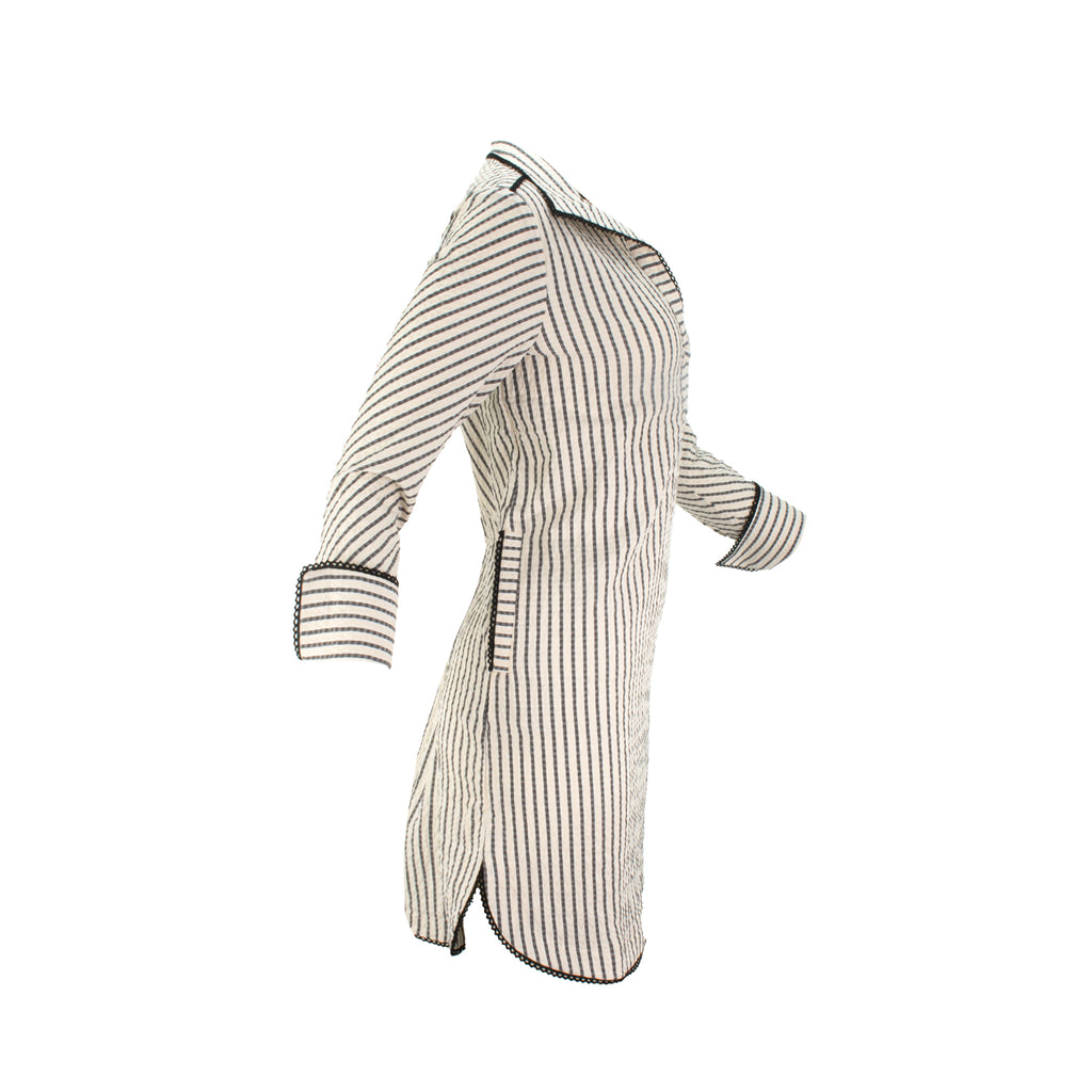The Urbino striped long sleeve collared pop-over shirt dress with vertical stripes, relaxed lapel neckline, contrast black trim detail, and lightweight breathable fabric