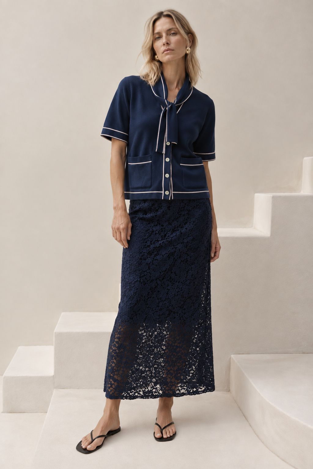 The Genoa women's short-sleeve cotton knit cardigan featuring a romantic tie-neck collar, contrast piping, and two front patch pockets.