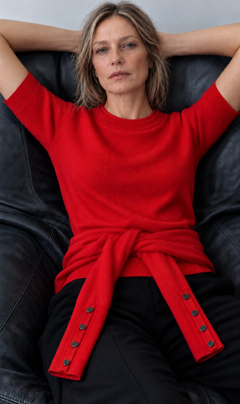 The Gee-Gee Tee in lipstick red with the Cammi Crewneck tied at the waist, snap cuffs showing, worn with black trousers