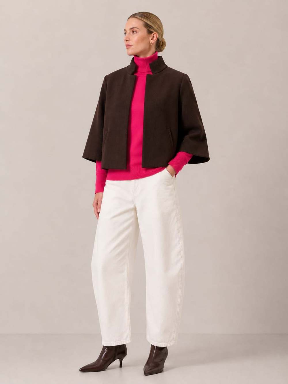 A woman in the Bristol Jacket in French Toast over a hot pink turtleneck with ecru wide-leg jeans